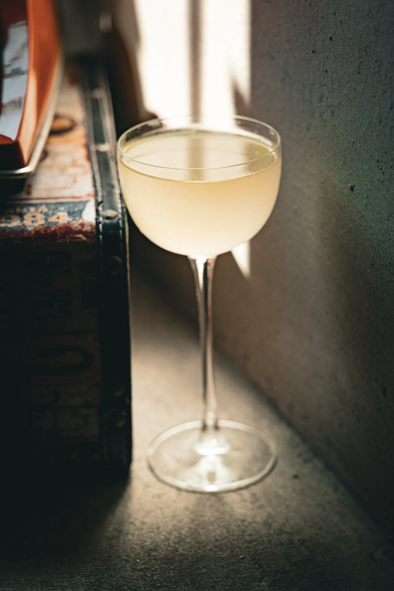 Coupe with a pale drink backlit on a concrete ledge